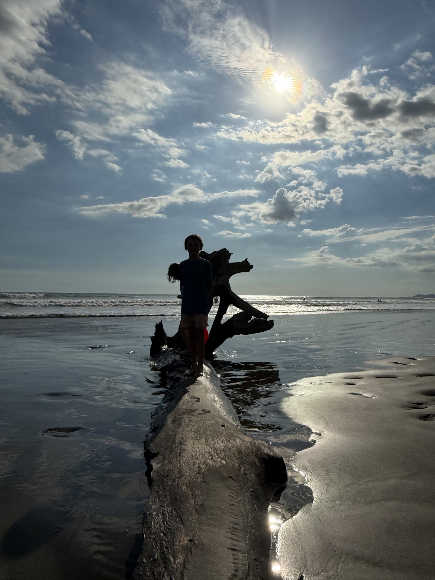Surfer walking the empty Pacific beach at low tide, Playa Coyote