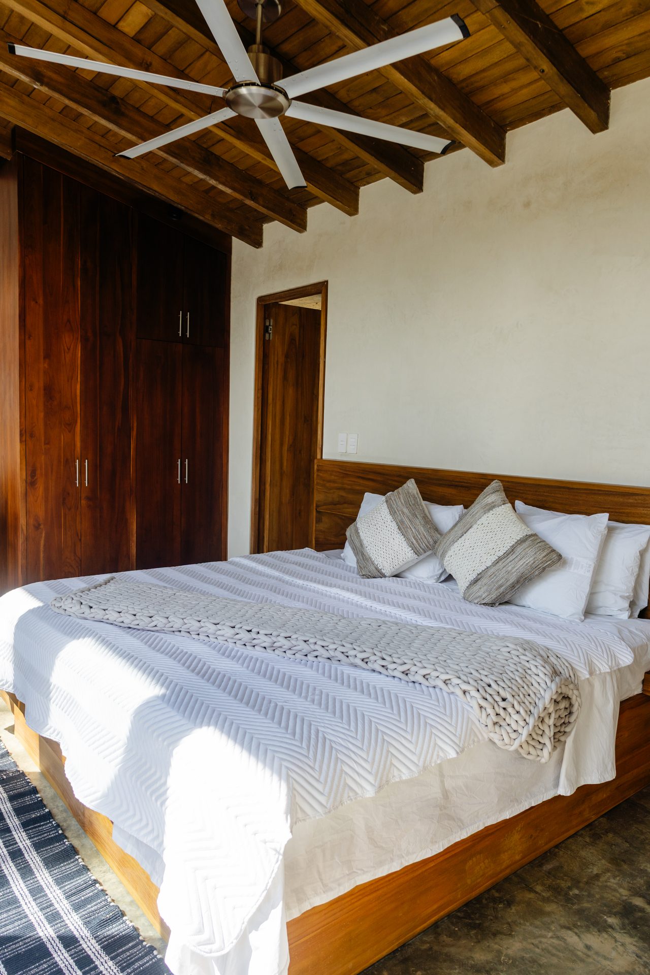 King bedroom with timber feature wall, beachfront family villa