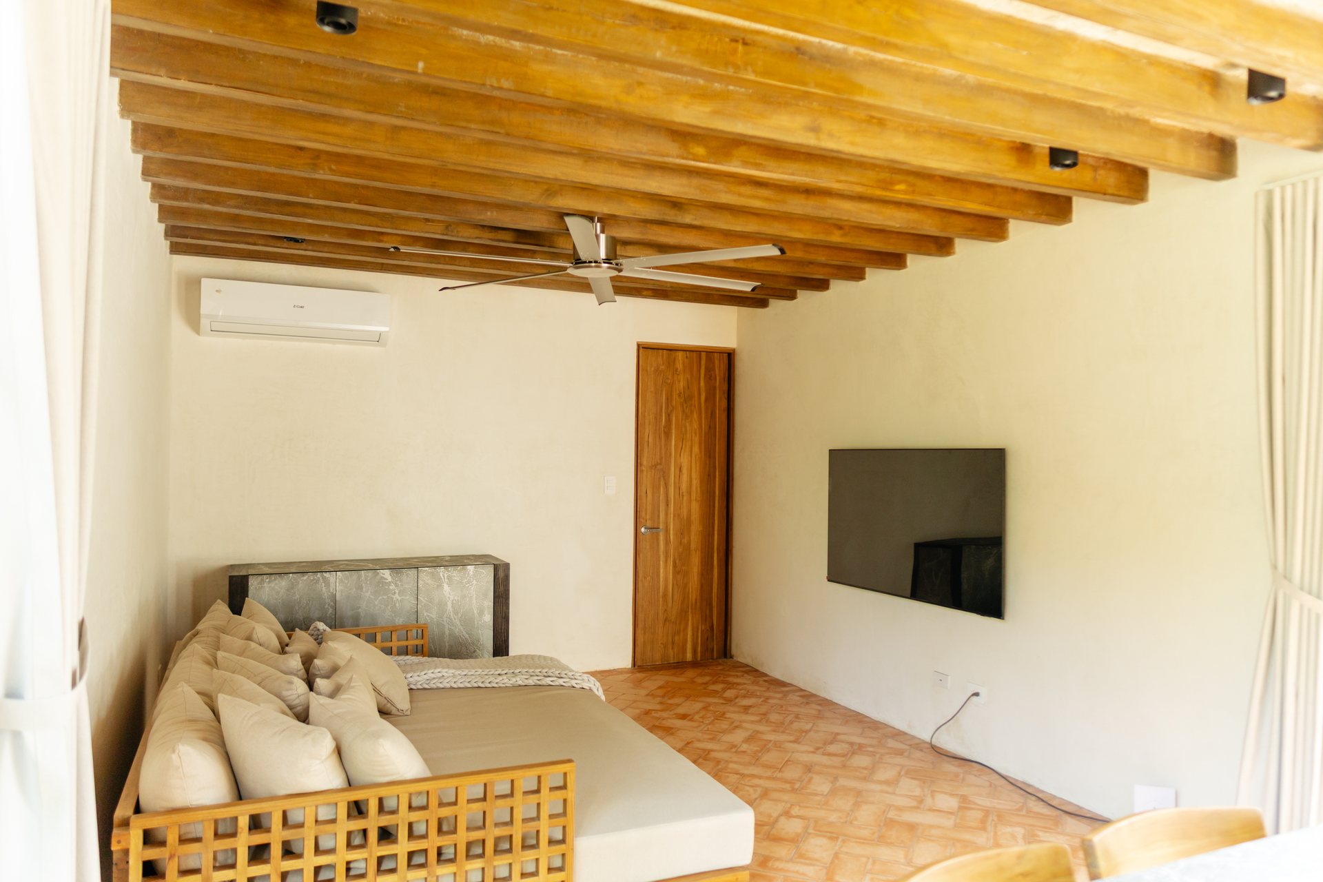 TV lounge with large daybed sofa and wall-mounted television, Mar del Sol Playa Coyote